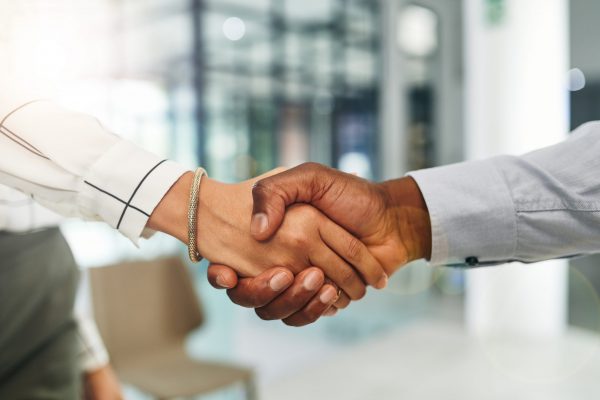 Closeup shot of two businesspeople shaking hands in an office