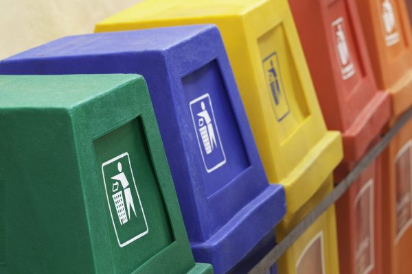 A row of recycling bins in different colors at a recycling station.